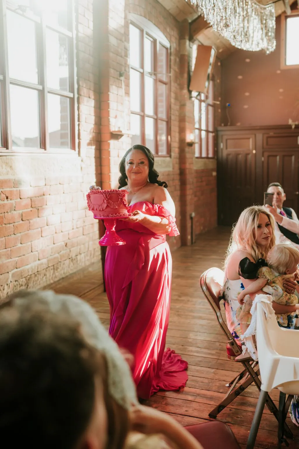 Bridesmaid carrying the pink Raspberry and White Chocolate wedding cake