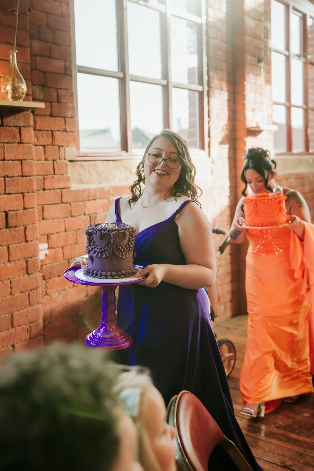 Bridesmaid carrying the purple Biscoff wedding cake