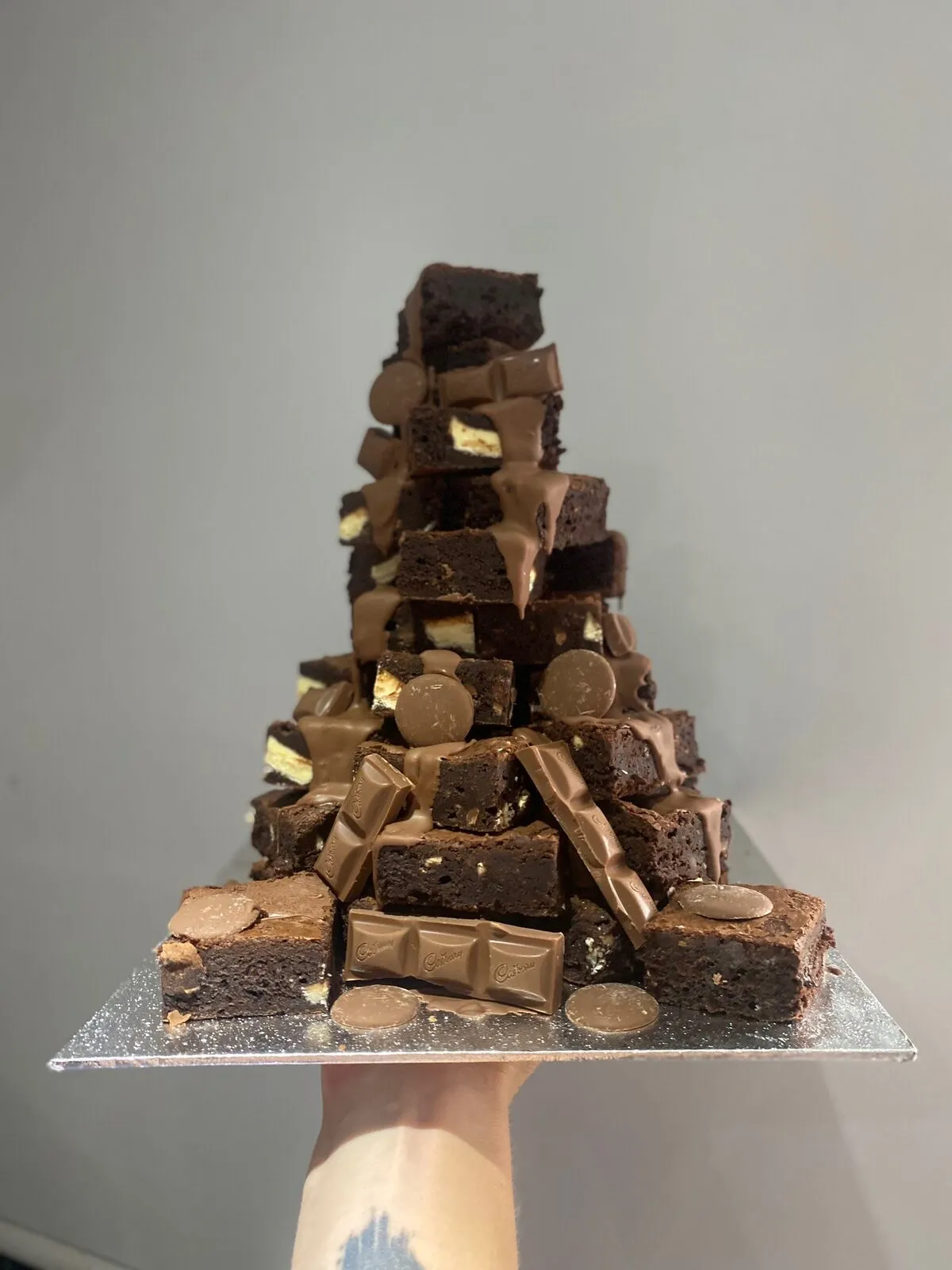 A brownie tower stacked with chocolate pieces for a dessert display