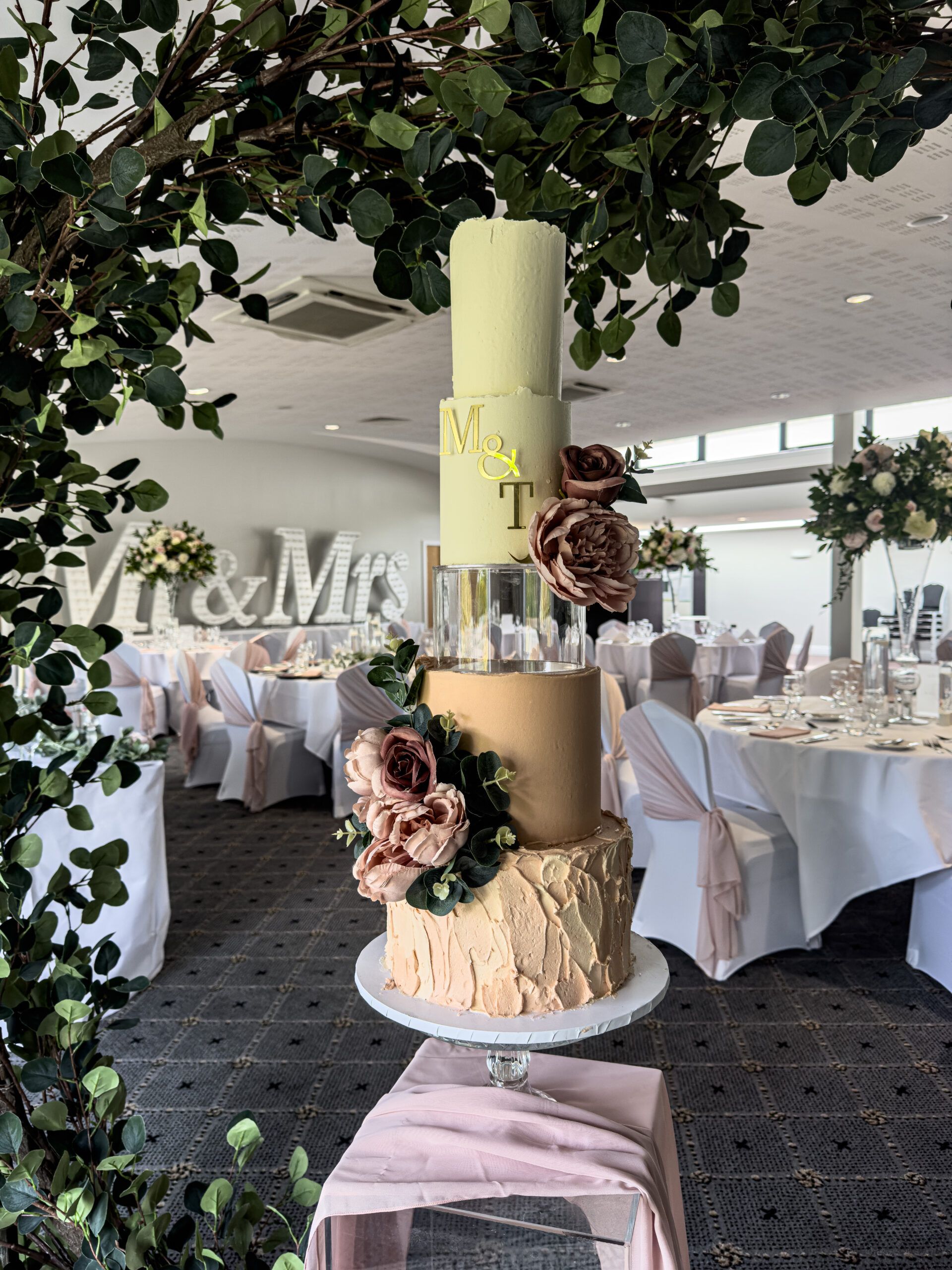Blush and gold three-tier wedding cake decorated with sugar roses at a Yorkshire wedding venue
