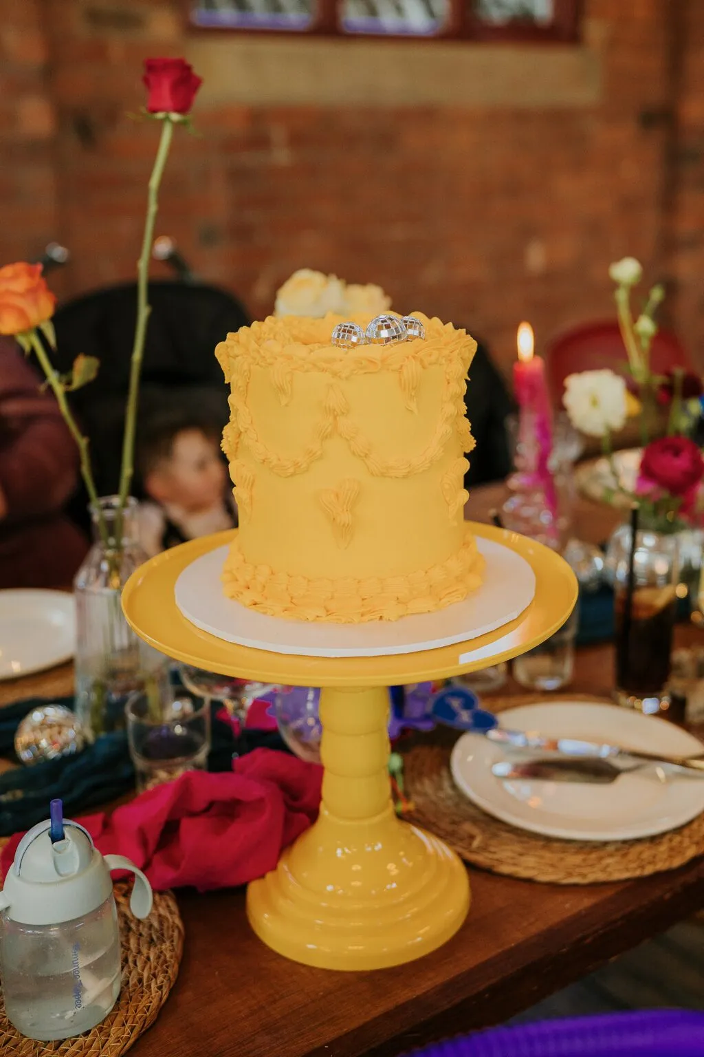 Yellow lemon Lambeth wedding cake on a yellow cake stand