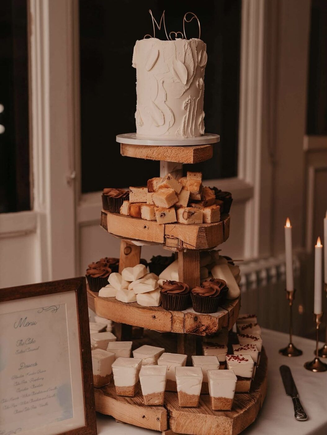 Rustic wooden-tier wedding dessert table with a cutting cake, brownies and mini desserts by Flourish & Flotts