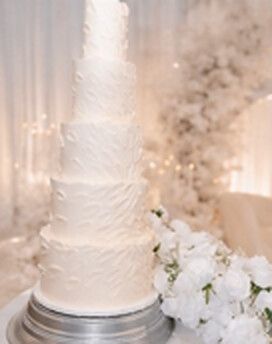 Five tier textured white wedding cake with white flowers
