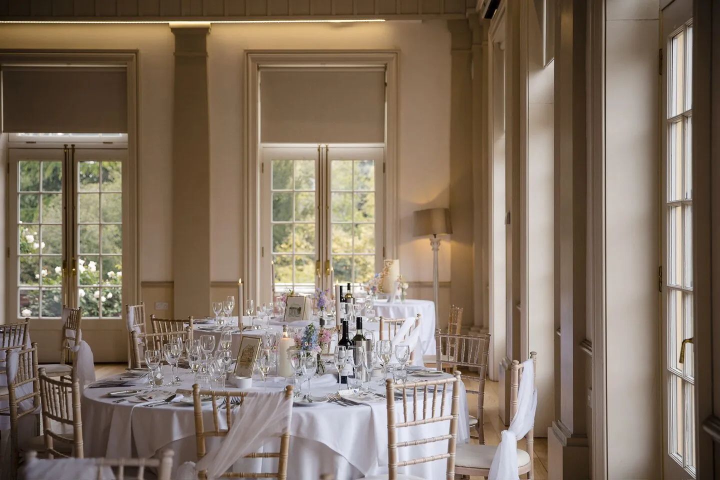 The reception room at Hodsock Priory set for the wedding breakfast, with the cake table by the window