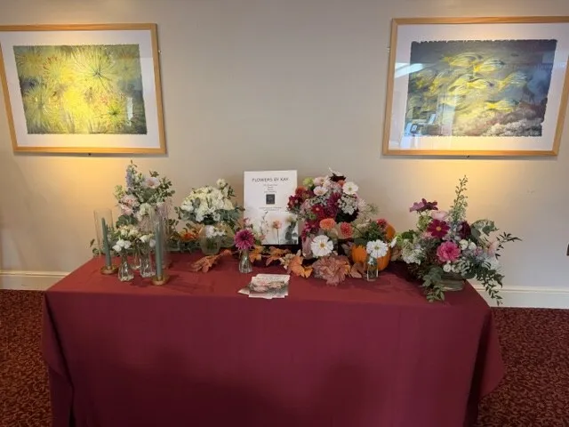 Colourful seasonal wedding flower arrangements on the Flowers by Kay table