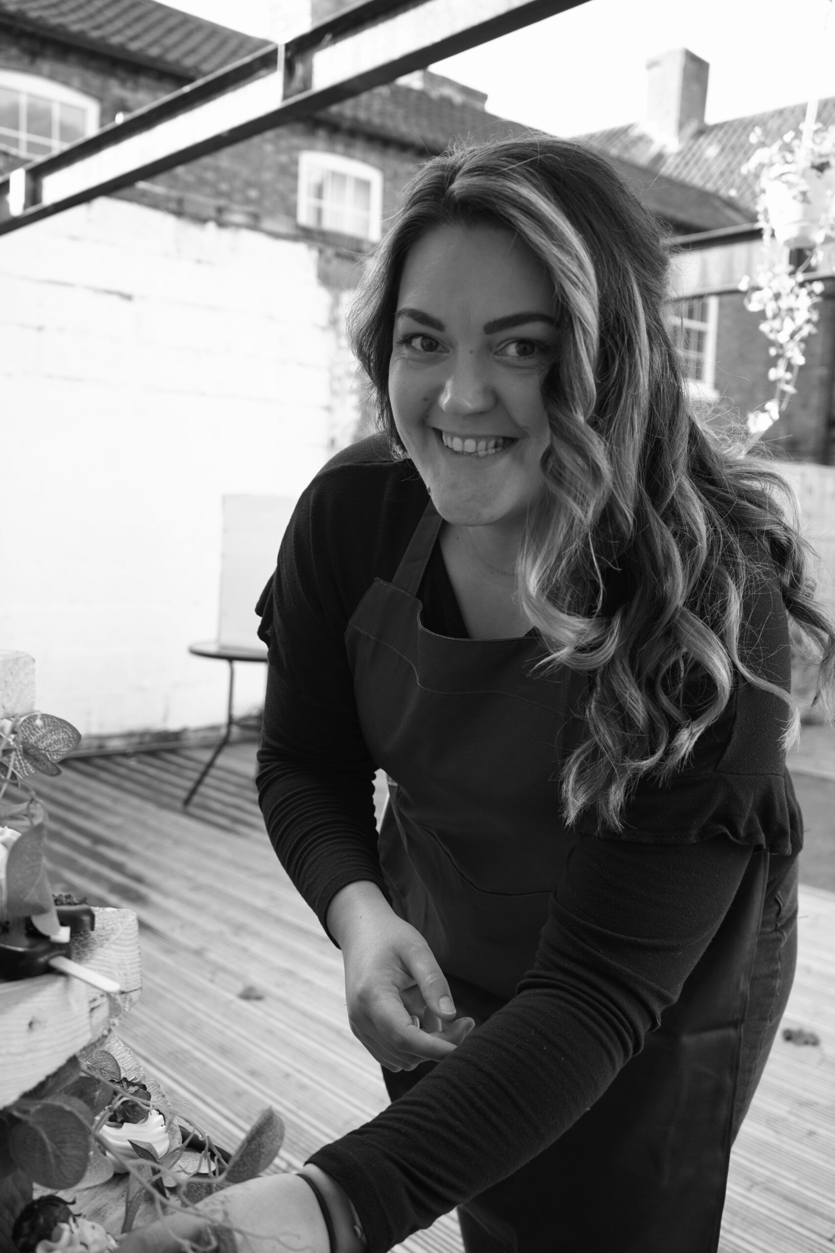 Tasha Ardron, founder of Flourish & Flotts, decorating a wedding cake